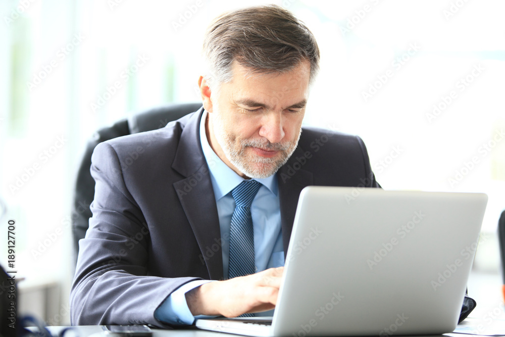 business, people and technology concept - happy smiling businessman with laptop computer office business, people and technology concept - happy smiling businessman with laptop computer office