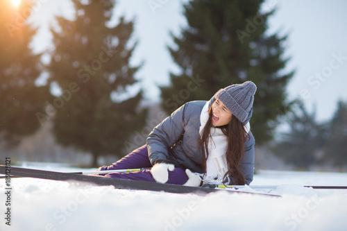 Young woman screaming from pain in her leg or knee after falling down during ski training