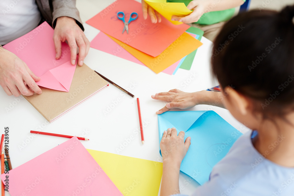 Secondary school learners using pink and blue paper while making origami Secondary school learners using pink and blue paper while making origami