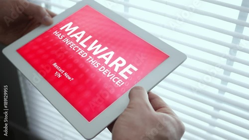 Man looks at Malware infected tablet in ambient room photo