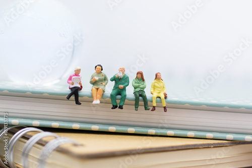 Wallpaper Mural Miniature people : Business team sitting on book and having a coffee break. Image use for business concept. Torontodigital.ca