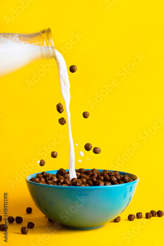 Photo Chocolate breakfast cereals and plant milk poured into the bowl, concept of brea
