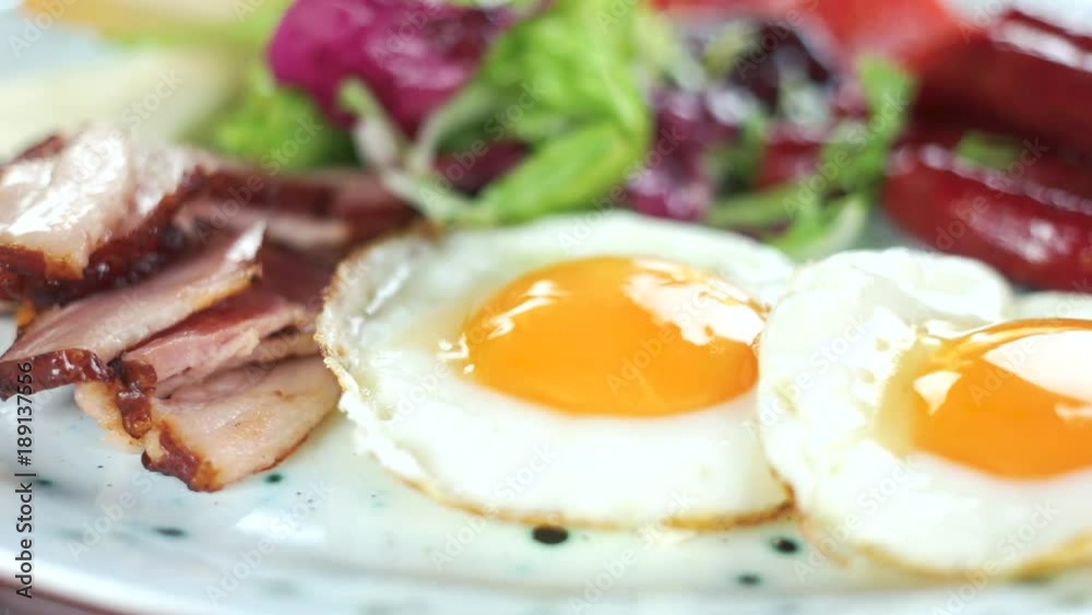 Fried bacon, eggs and sausages. High calorie food. Fried bacon, eggs and sausages. High calorie food.