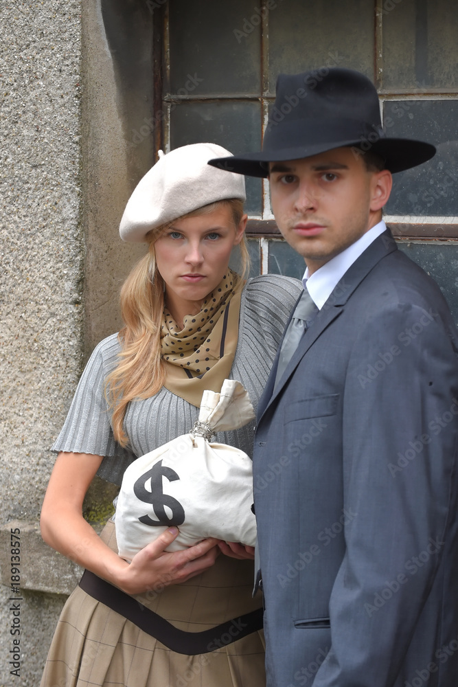 Two models get dressed up in 1930's style vintage fashion clothes and act  the role of the gangster duo Bonnie and Clyde. Stock Photo | Adobe Stock