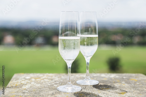 Two champagne glasses on stone with cityscape panorama