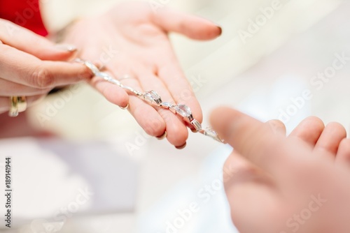 Female seller in a luxury jewelry store presents a bracelet