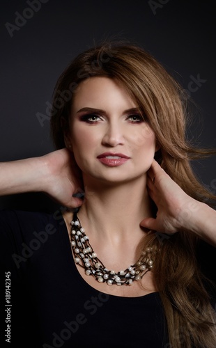 Studio beauty shot of woman with white pearl necklace.