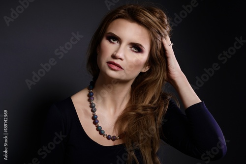 Studio beauty shot of woman with agate stone necklace.