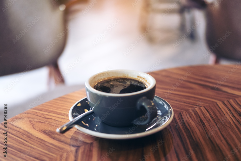 Fototapeta Closeup image of hot Americano coffee cup on vintage wooden table in cafe