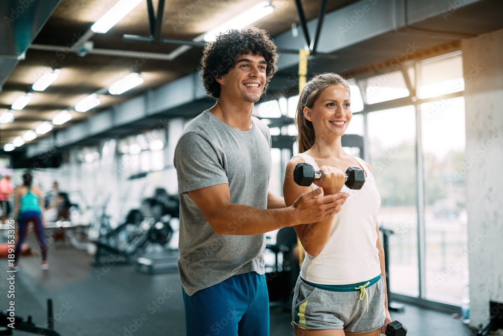 Young beautiful woman doing exercises with personal trainer Young beautiful woman doing exercises with personal trainer