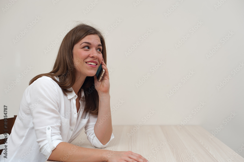 Portrait of successful businesswoman talking on smartphone on white wall background Portrait of successful businesswoman talking on smartphone on white wall background