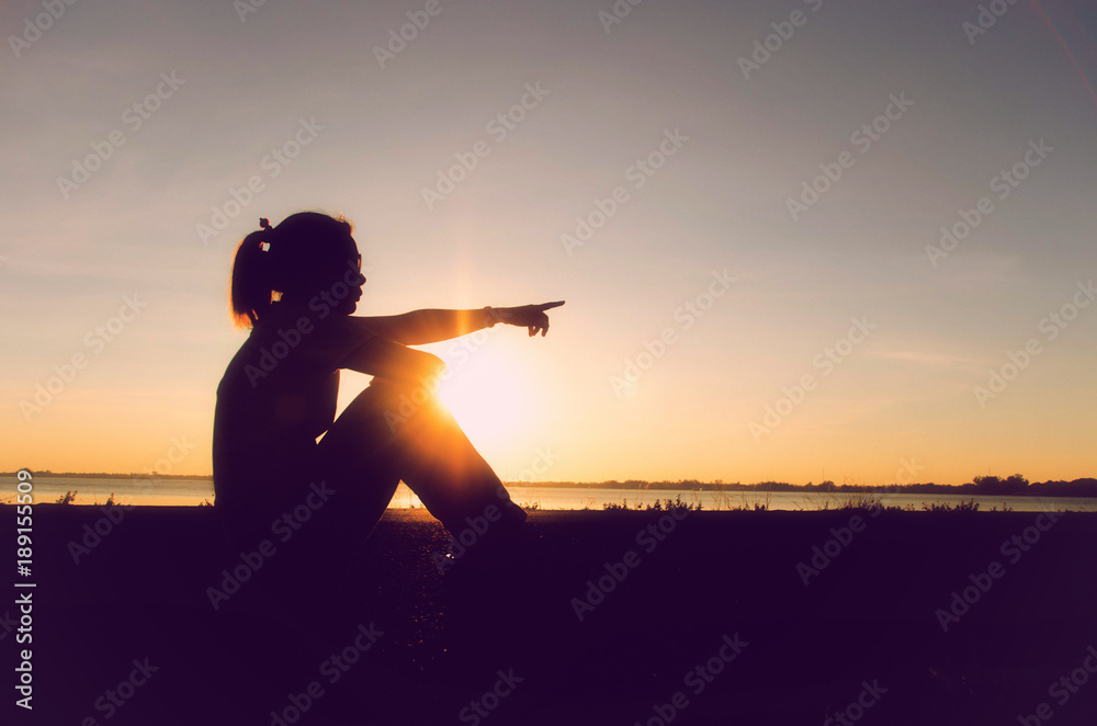 Portrait of a sad woman in a sunset with the sun in the background