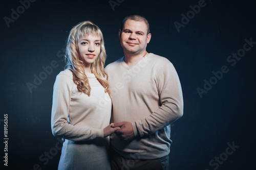 Man and woman in a white dresses lighted colored light in studio and black background