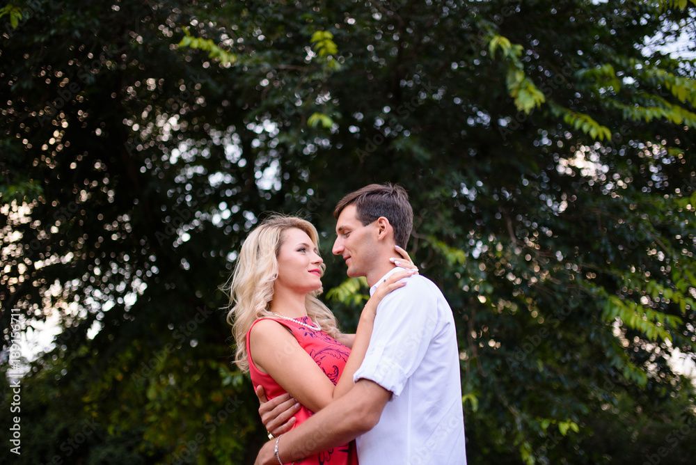A loving couple hugs and walks in the park. A loving couple hugs and walks in the park.