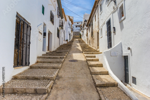 Steep narrow road with white houses in Altea