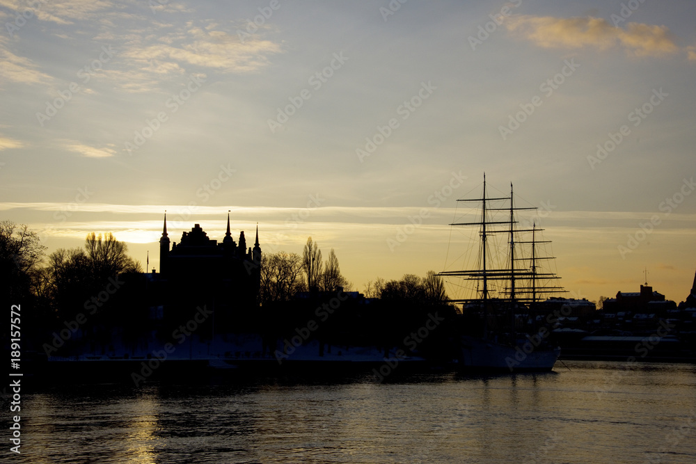 Silhouette of ship and old house at sunrise at Stockholm waterfront in winter