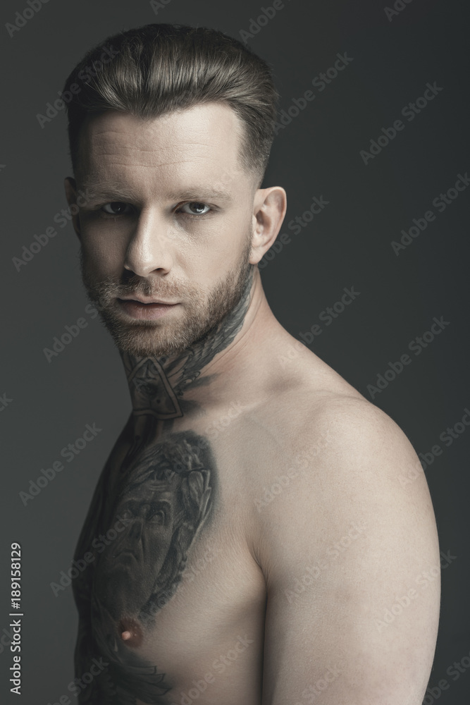 Fototapeta premium handsome shirtless tattooed man, isolated on grey