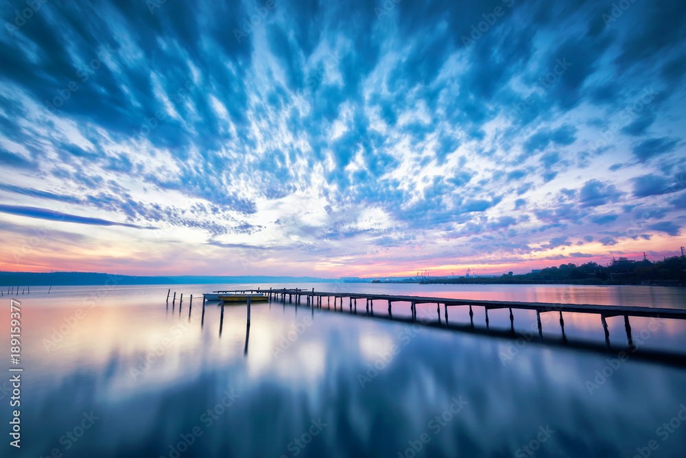 Amazing lake sunset /
Magnificent long exposure lake sunset with boat and a wooden pier