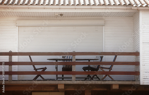 stylish summer rental chalet balcony, with chairs and table in warm wood