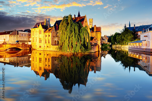 Canal in Bruges and famous Belfry tower on the background at sunset, night, Belgium