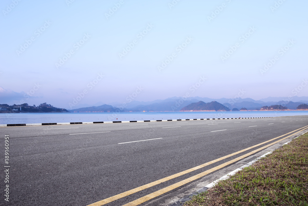 empty asphalt road with beautiful lake