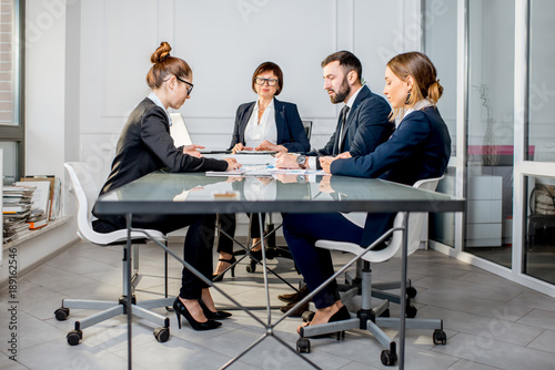 Business people working with charts and documents sitting at the table during the conference in the office