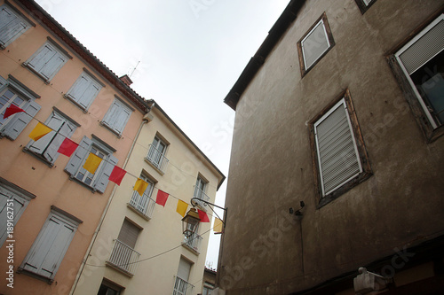 Corner buildings of village square, with red and yellow coloured catalan flags 