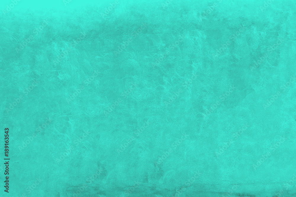 Vivid green turquoise color coarse facade wall as an empty rustic background texture space.