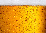 close-up view of glass of beer with big droplets and foam