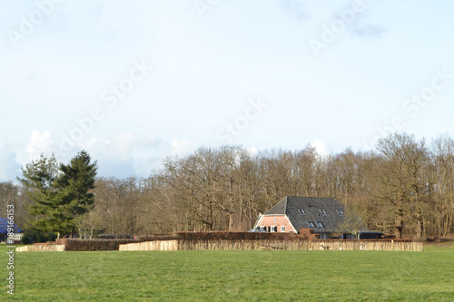 donkere wolken boven een boerderijtje in de Kruisbergse bossen photo