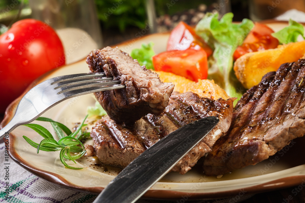 Succulent portions of grilled fillet mignon served with baked potatoes