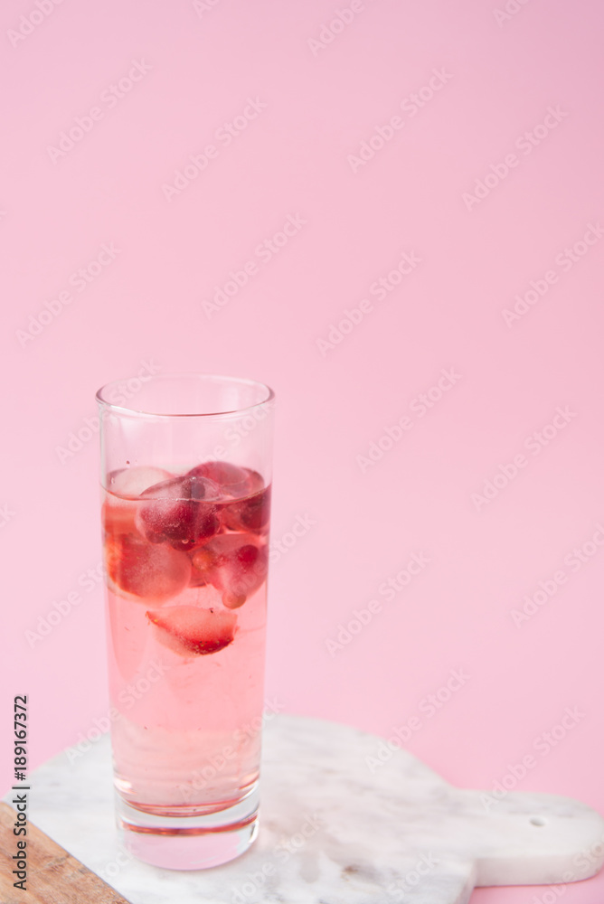 A glass of cocktail with frozen strawberry and lingonberry A glass of cocktail with frozen strawberry and lingonberry