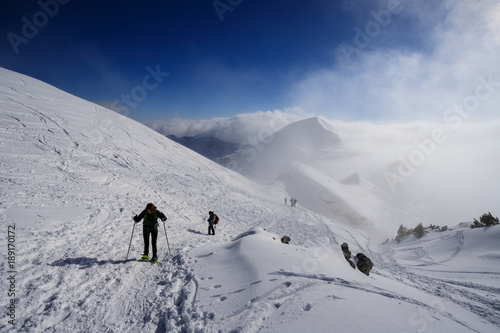 alpinisti che scendono dalla cima di Piazzo. Sullo sfondo mi monte Sodadura tra le nubi - alpi Orobie