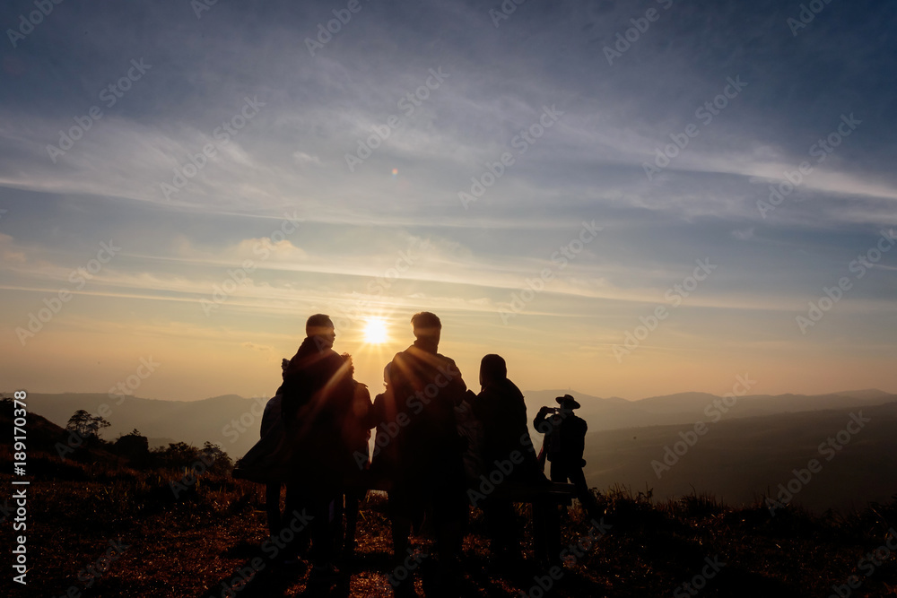 Silhouette of people on top of mountain seeing sunrise in the morning, Phu Lom Lo, Loei, Thailand.