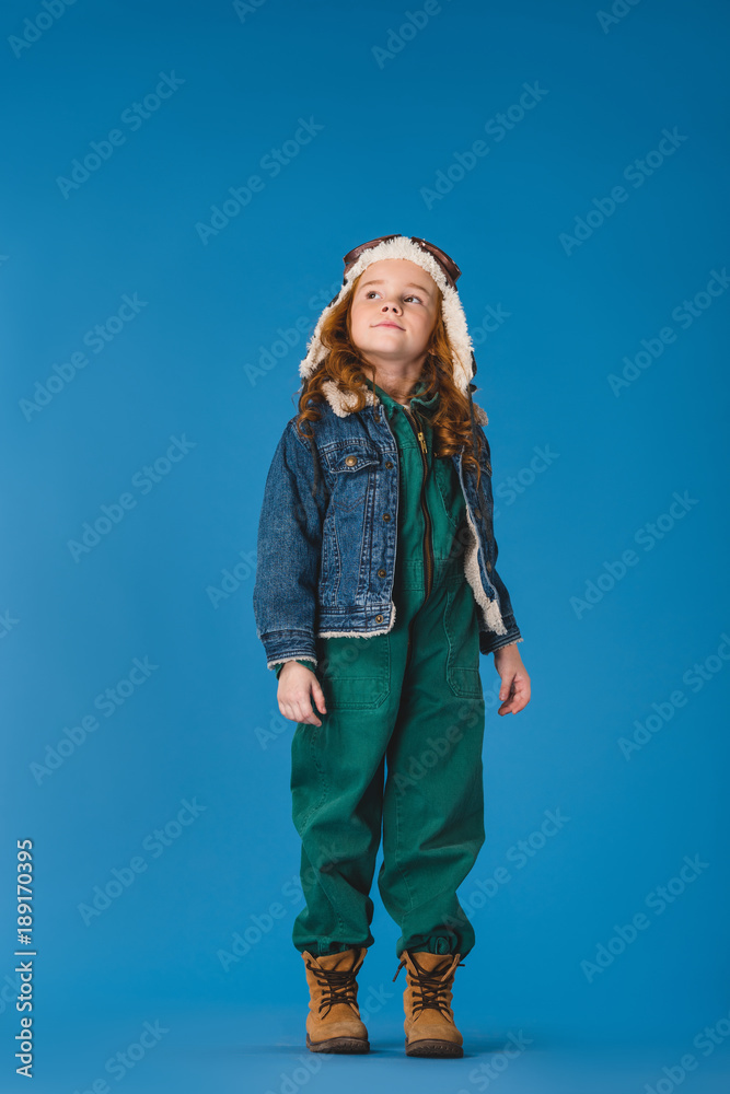 adorable preteen kid in pilot costume looking away isolated on blue adorable preteen kid in pilot costume looking away isolated on blue