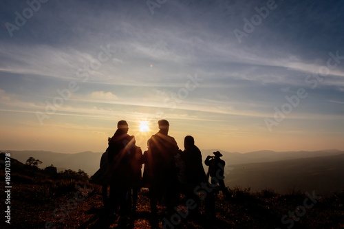 Silhouette of people on top of mountain seeing sunrise in the morning, Phu Lom Lo, Loei, Thailand.