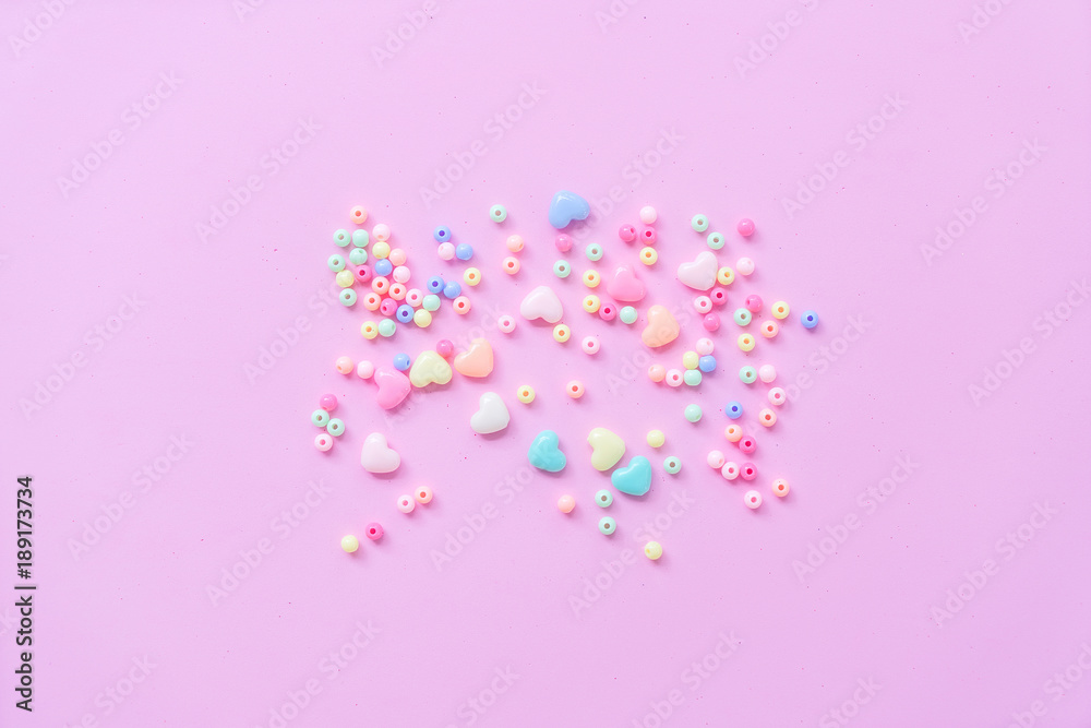 The 14th of February. St. Valentine's Day. Background with multicolored beads balls and hearts on a pink background. Top view with copy space