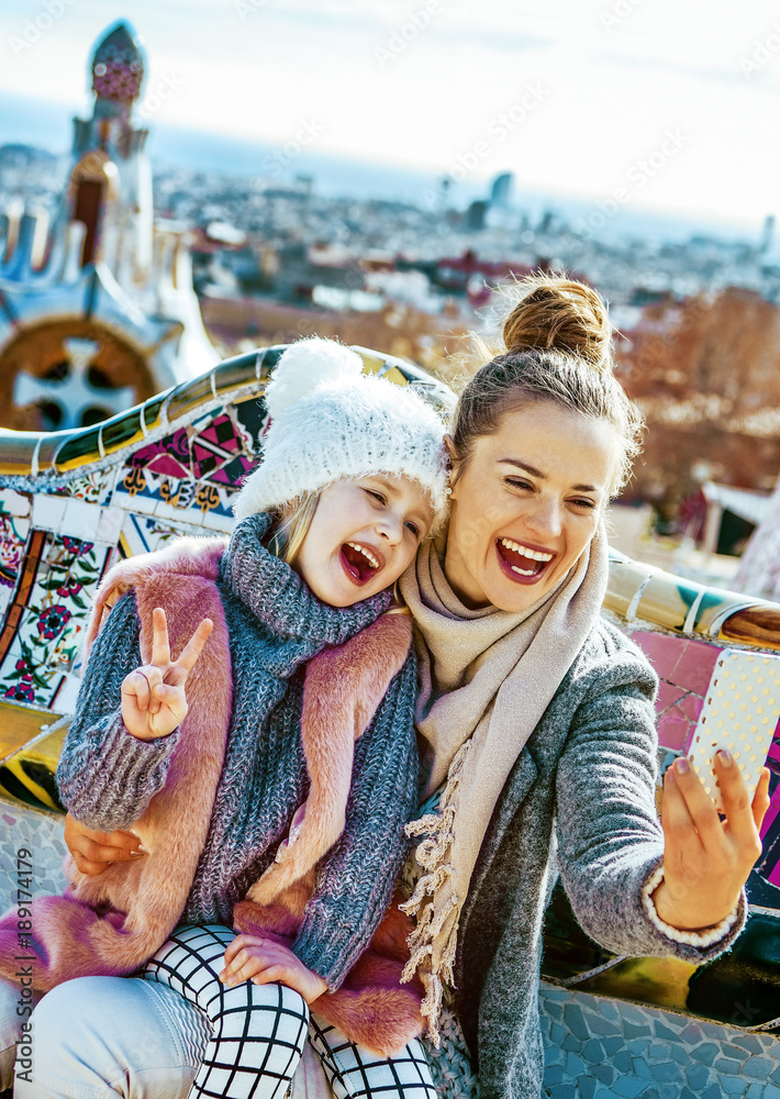 Naklejka premium podróżujący matka i córka robią sobie selfie w Guell Park