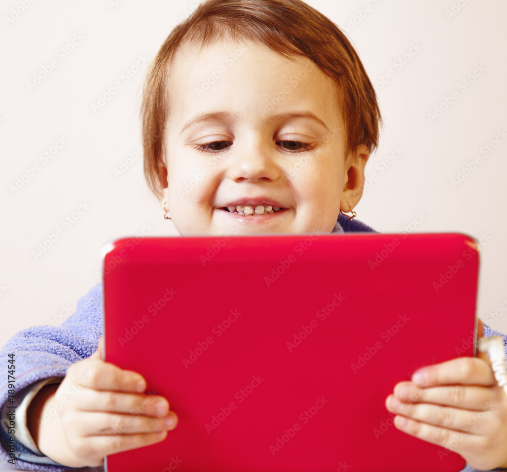 Social Media addiction. Happy little child girl holding tablet as symbol of psychological problems of media mania. Social Media addiction. Happy little child girl holding tablet as symbol of psychological problems of media mania.