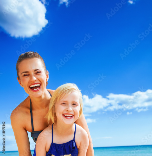 happy young mother and daughter on seacoast having fun time