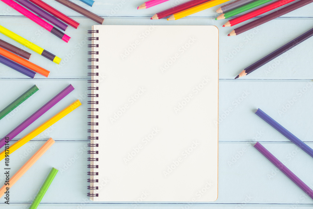 Blank notebook with colorful pencil on blue wooden table,top view Blank notebook with colorful pencil on blue wooden table,top view