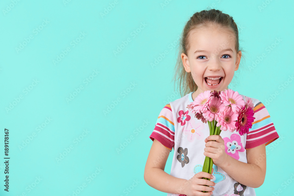 Adorable little girl with cheeky smile and face expression holding bouquet of pink gerbera daisies. Happy Mother's Day, Women's day, Father's day or Birthday background. Adorable little girl with cheeky smile and face expression holding bouquet of pink gerbera daisies. Happy Mother's Day, Women's day, Father's day or Birthday background.