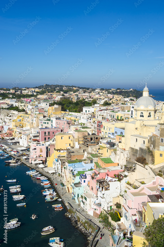 Bright morning sunrise view of picturesque Corricella harbour village on the Flegrean island of Procida, a day trip from the port of Naples, Italy