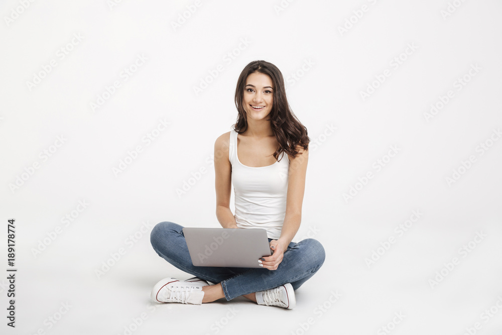 Portrait of a smiling girl dressed in tank-top holding laptop Portrait of a smiling girl dressed in tank-top holding laptop