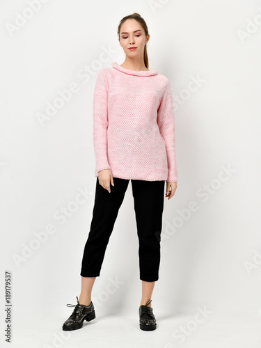 Young beautiful woman posing in new casual pink sweater