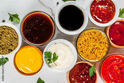 Wallpaper Mural Set of different sauces - ketchup, mayonnaise, barbecue, soy, teriyaki, mustard, grain hills, pesto, adzhika, chutney, tkemali, pomegranate sauce on white marble background. Top view copy space Torontodigital.ca