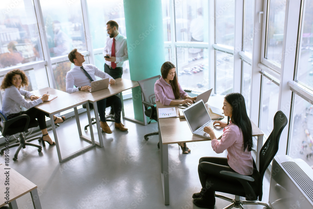 Team members in comfortable office discussing project milestone. Business concept. Team members in comfortable office discussing project milestone. Business concept.