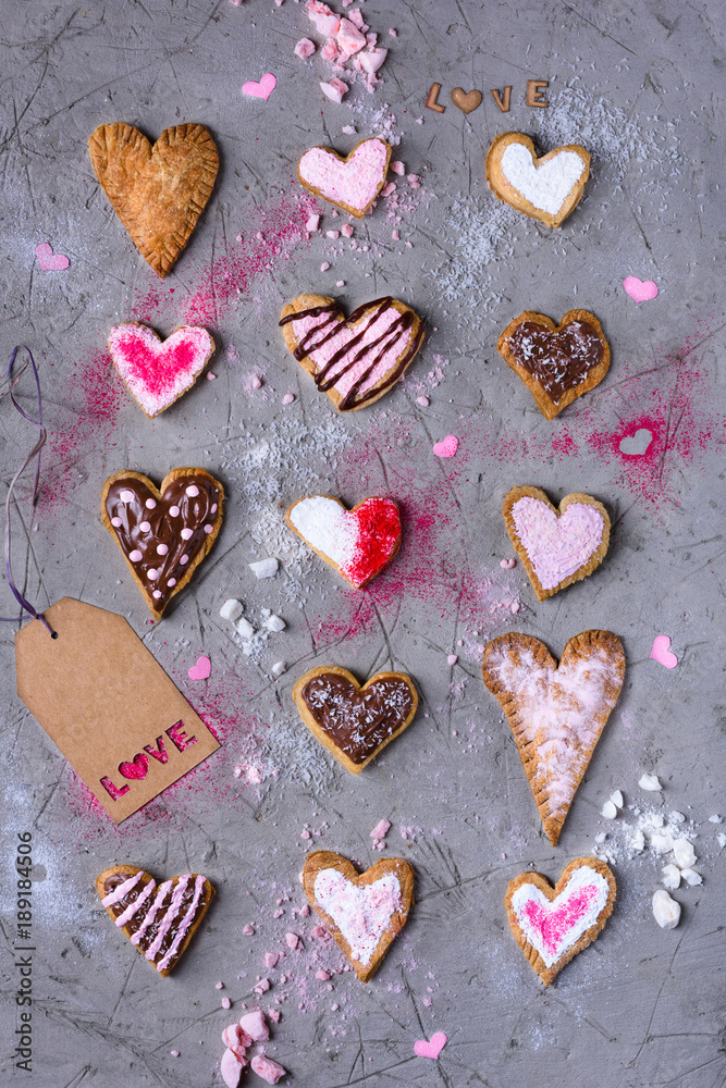 top view of sweet traditional heart shaped cookies with love tag on grey cracked surface top view of sweet traditional heart shaped cookies with love tag on grey cracked surface
