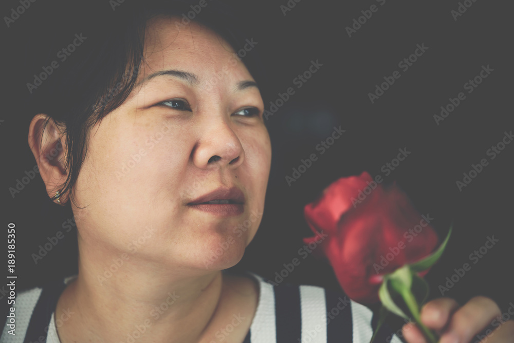 Woman smelling Red rose flower in Valentine's Day