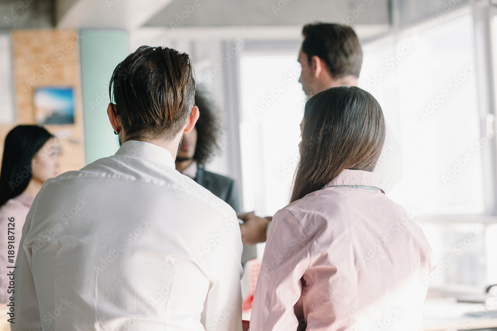 Fototapeta premium Close up image of managers backs, who attentively listening to colleagues.